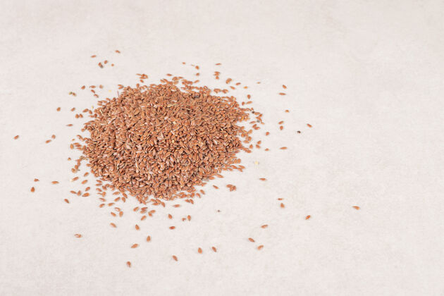 种子棕色的小麦颗粒被隔离在混凝土上有机清淡顶部视图