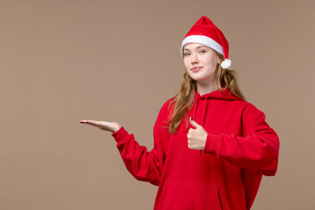快乐正面是棕色空间上穿着红色斗篷的圣诞女孩工人制服新