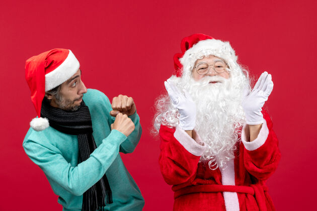 圣诞老人正面图：圣诞老人和年轻的男性站在一起圣诞红色年轻