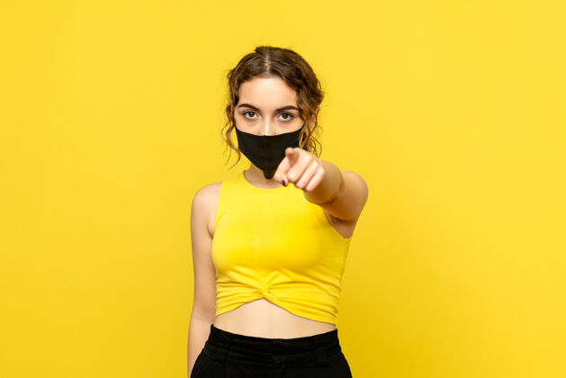 肖像戴面具的年轻女子正对着黄色的墙壁模特年轻人流行
