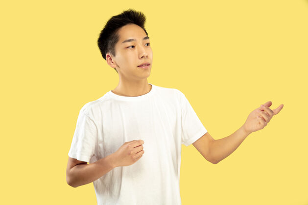 长相韩国年轻人的肖像穿白衬衫的男模展示一些东西人类情感的概念 面部表情前视图流行的颜色表情人人