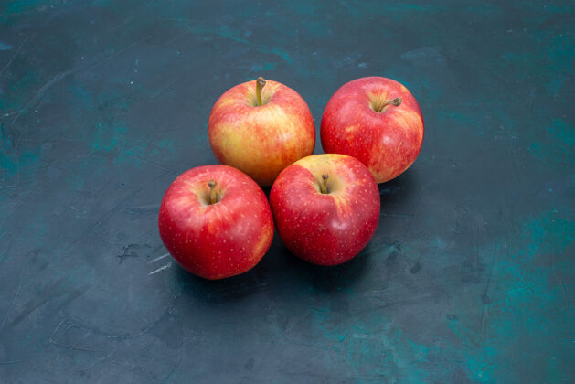 生的前视图新鲜的红苹果醇厚和新鲜的水果在深蓝色的桌子上水果新鲜醇厚成熟的树可食用的视野苹果