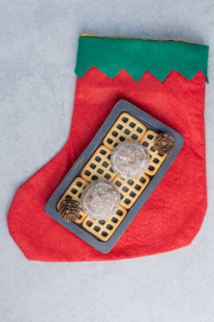 蛋卷把饼干和饼干放在大理石表面的圣诞长袜上松树长袜美味