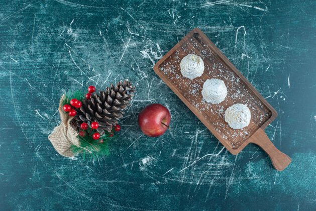 糖香草蛋糕放在一个小盘子里 一个苹果和一个蓝色的圣诞装饰品顶视图美味粉末