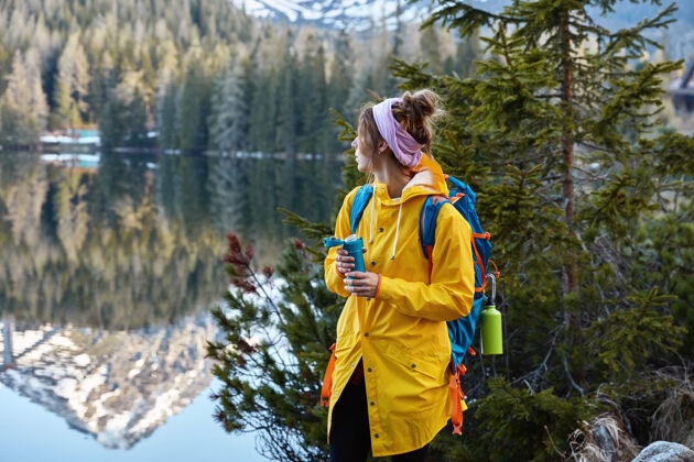 饮用平和的户外风景让女性游客仰慕美丽的山林湖 目不转睛个性冒险背包