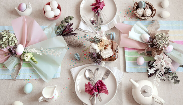 桌子用复活节甜点 茶叶和鸡蛋装饰的节日餐桌复活节快乐概念装饰餐具公寓