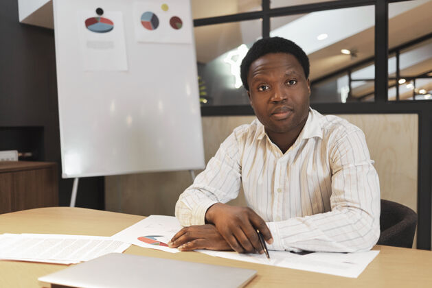 帅哥严肃自信的非洲ceo穿着正式的条纹衬衫坐在会议室里公司年轻男人