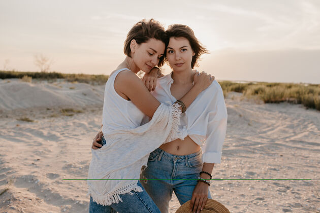 女孩两个年轻女子在日落海滩上玩得很开心 男女同性恋爱情浪漫Lgbt大笑同性恋