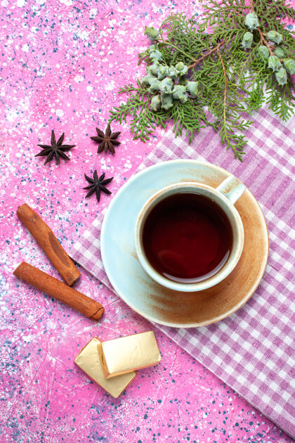杯子一杯加糖和肉桂的茶放在粉红色的桌子上糖果茶棕色