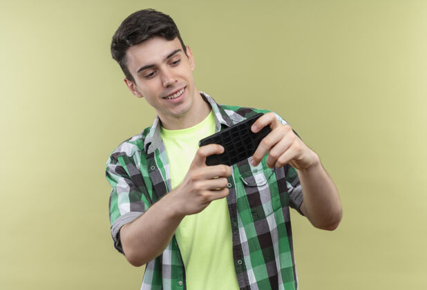 电话微笑的白人年轻人穿着绿色衬衫 在孤立的绿色背景下打电话游戏穿着年轻游戏