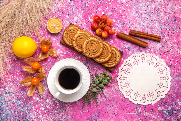 柠檬浅粉色表面上点缀着柠檬茶和肉桂的美味小饼干俯瞰图饮料肉桂茶