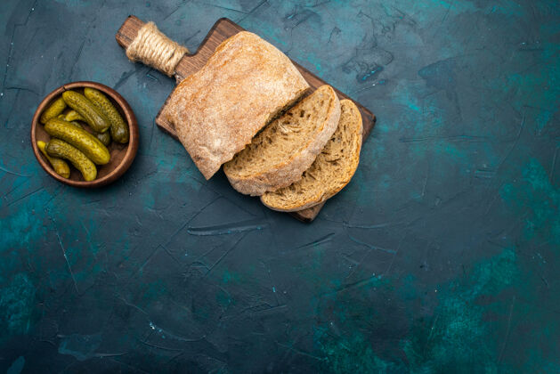 面包在深蓝色的桌子上俯瞰着腌菜面包美味腌菜食物