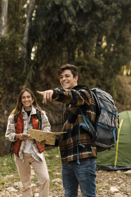 旅游森林里的幸福夫妻拿着地图指路露营旅行探险