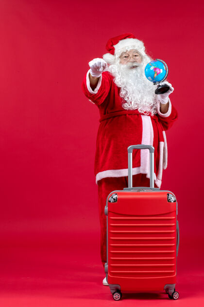 节日红墙上准备旅行的圣诞老人的前视图快乐十二月包