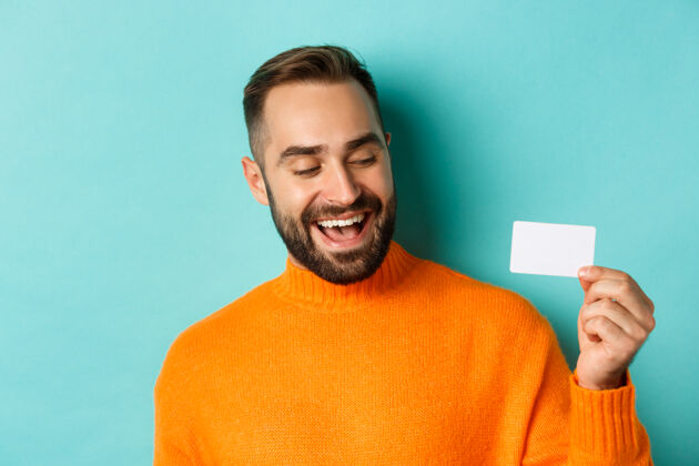 信用卡白种人帅哥展示信用卡和微笑的特写镜头酷情感买家