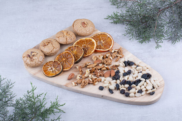 树枝饼干 桔子和各种坚果放在木板上坚果葡萄干切片