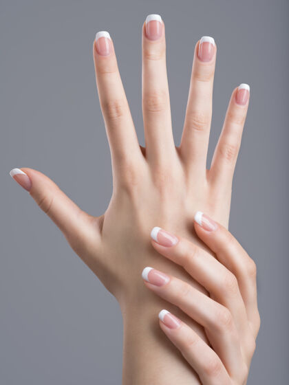 指甲美丽的女性手 指甲上有法式美甲手指法语优雅