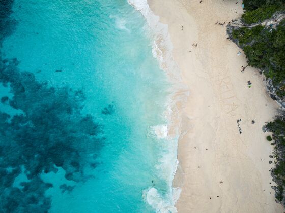 热带空中拍摄被绿色植物和大海包围的海滩绿色蓝色放松