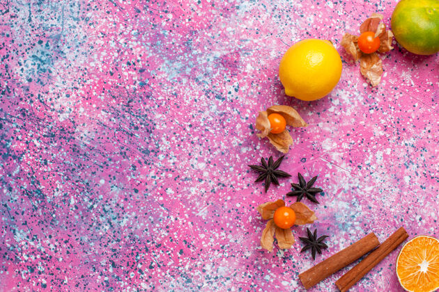 浅粉色在浅粉色的背景上俯瞰新鲜的酸橘子和柠檬和肉桂食物苹果柑橘