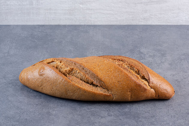烘焙大理石上的一条面包面粉面团面包