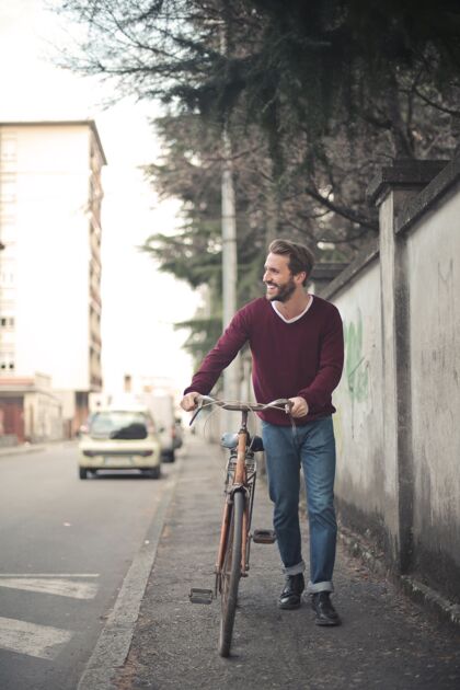 自行车一个年轻男子在人行道上骑自行车的垂直镜头轮胎城市男