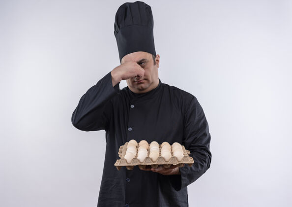 厨师神经质的中年男厨师穿着厨师制服拿着一批鸡蛋闭着鼻子鸡蛋批制服