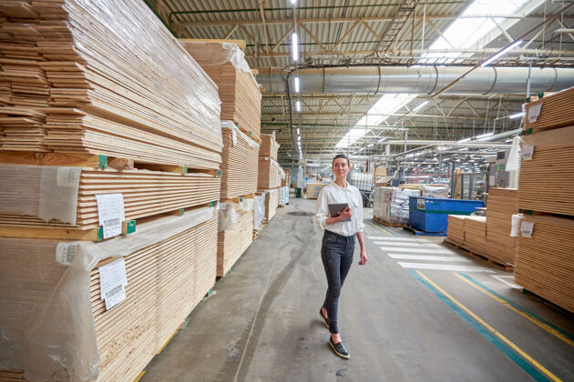 小企业女商人画像在木工厂使用的平板电脑工厂木材木板