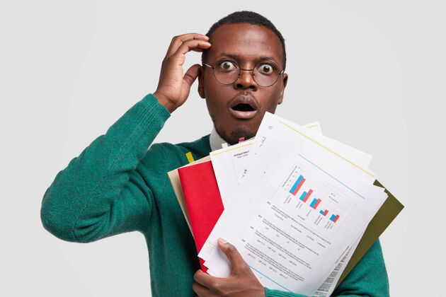 非洲了不起的黑皮肤企业家拿着带有图表的文件 惊讶于公司的低收入 检查财务计划 戴着眼镜表情凝视男性