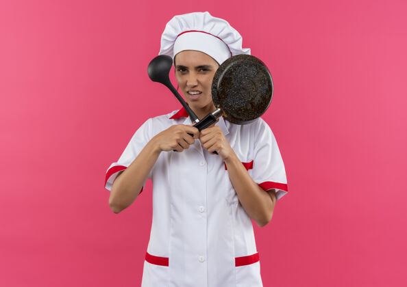平底锅穿着厨师制服的年轻女厨师手拿煎锅和勺子 手拿勺子 手拿勺子拿着穿未出租