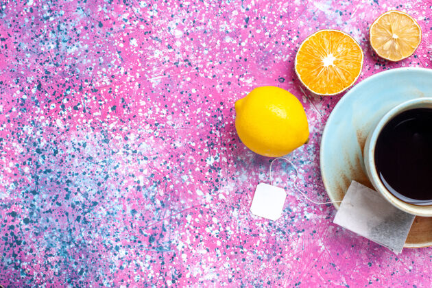新鲜在粉红色的桌子上放一杯柠檬茶糖果柑橘水果