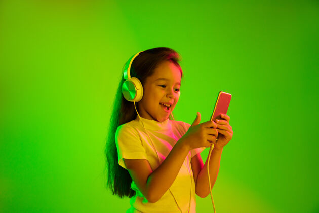 Waves美丽的女性半身像 隔离在霓虹灯下的绿色背景上年轻感性的女孩人类情感 面部表情概念使用智能手机进行虚拟博客 自拍 聊天 游戏青少年微笑Person