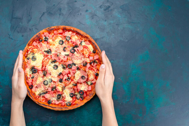 切片俯瞰图蓝色桌子上烤着美味的披萨 上面放着橄榄香肠和奶酪香肠食物比萨饼