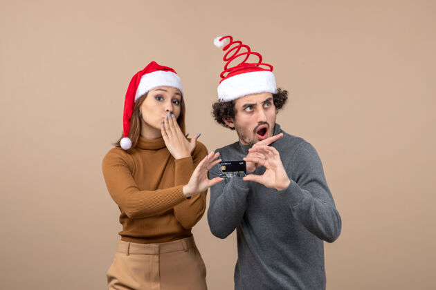 圣诞老人圣诞心情激动满意酷酷情侣戴红色圣诞老人帽出示银行卡人物帽子卡片