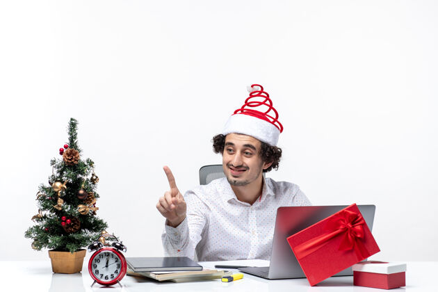 年轻快乐积极的年轻商人 戴着滑稽的圣诞老人帽 在白色背景下和办公室里的人说话办公室商人卖家