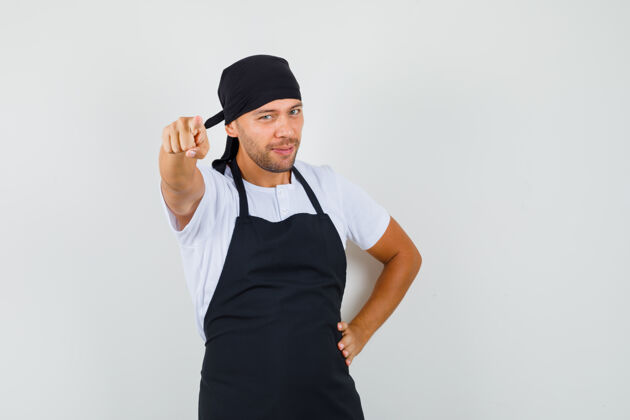 指向面包师穿着t恤 围裙指着摄像机 看上去很自信面包师美味工作