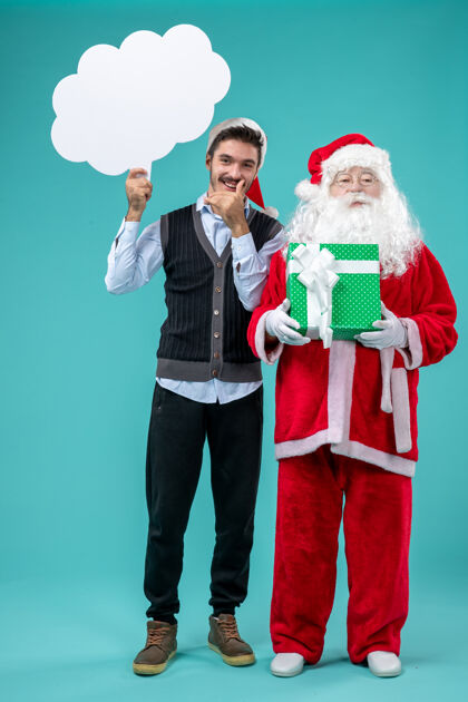 服装前视图圣诞老人与年轻男子谁持有白云标志蓝色地板圣诞新年假期雪的颜色圣诞老人男性云