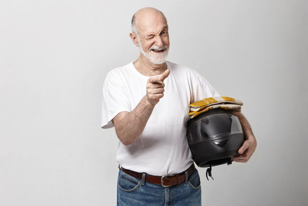 老年人帅气积极情绪成熟的老胡子秃头男子手持摩托车头盔服装摩托车手摩托化