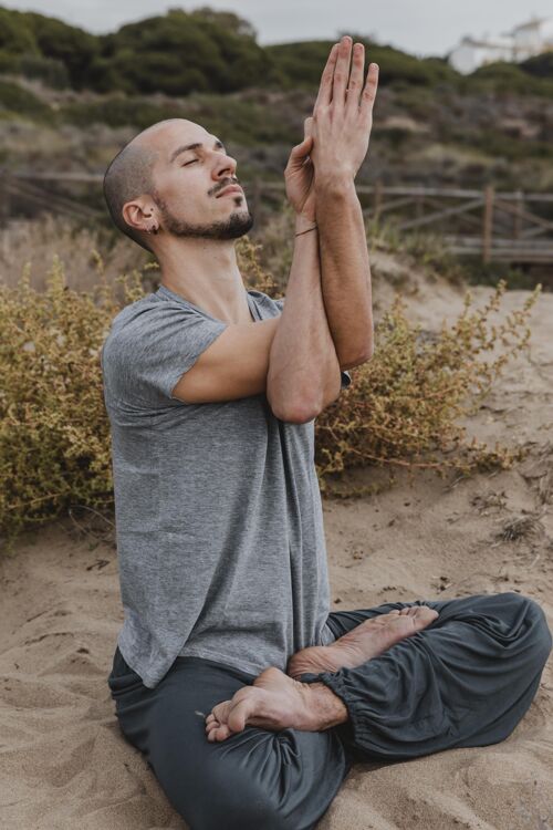 冥想一边做瑜伽一边冥想的男人的侧视图瑜伽男性训练