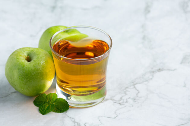 草药一杯青苹果保健茶放在新鲜青苹果旁边苹果苹果酒颜色