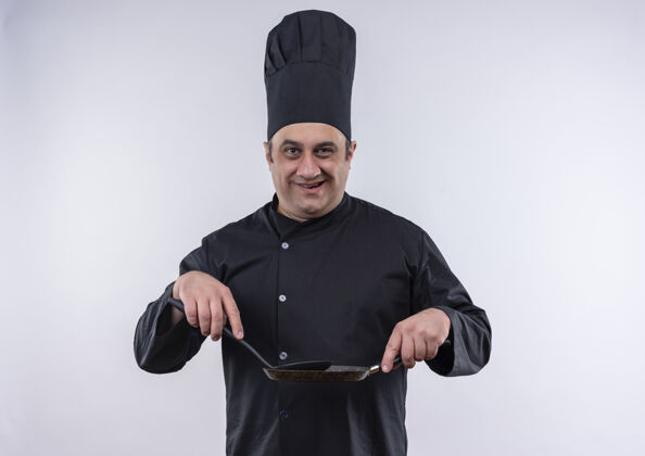 厨师微笑的中年男厨师 身着厨师制服 手里拿着煎锅和锅铲男中年厨师