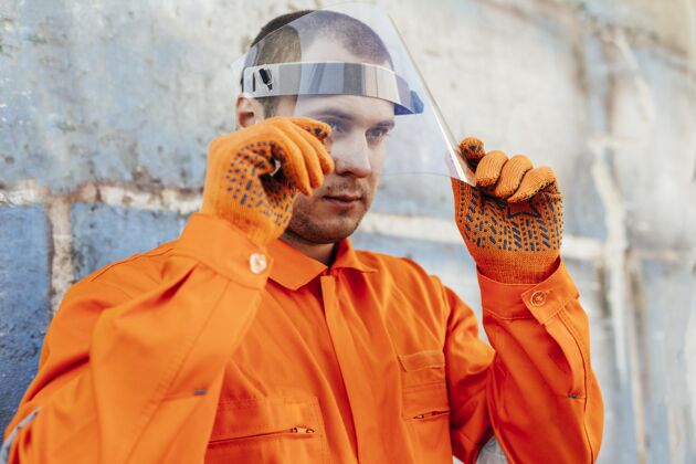 工作服穿制服 戴面罩和防护手套的工人安全盾制服