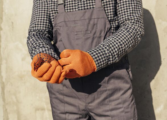 工作穿制服戴防护手套的男工人的正面图男性预防工人