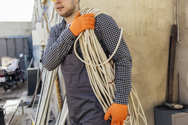 工作服戴安全帽的工人 带着绳子职业工作安全