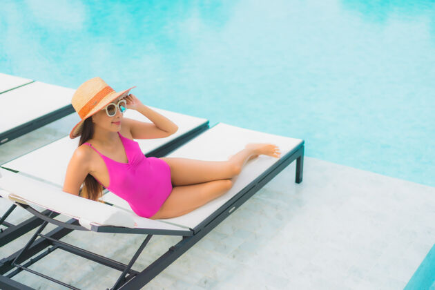 身体肖像美丽的亚洲年轻女子放松微笑周围的室外游泳池在酒店度假村放松泳装海滩