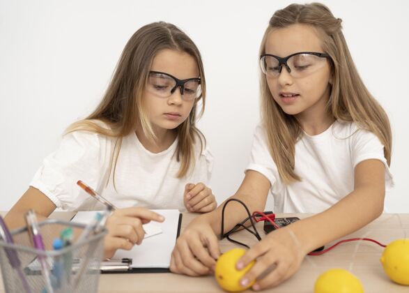 安全眼镜两个女孩用柠檬做科学实验柠檬乐趣学校