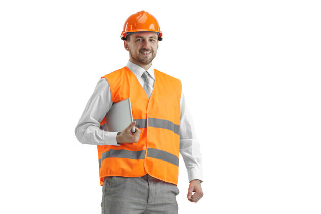 男人一个穿着建筑背心 戴着带石碑的橙色头盔的建筑工人工业专家建筑