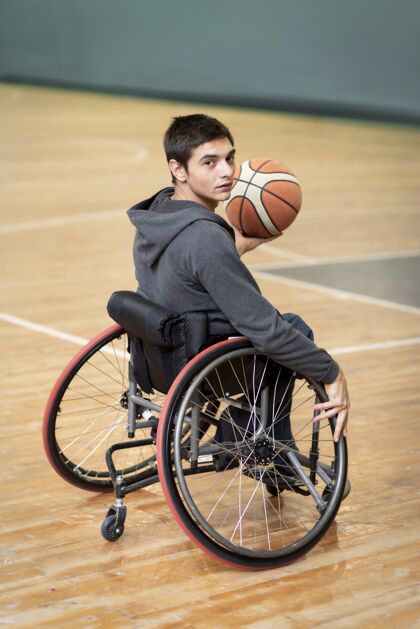 残疾人一个拿着球的年轻残疾人健康轮椅坐着