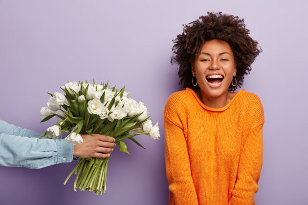 牙齿快乐的非洲裔美国女士的照片真诚地笑 从丈夫或男友那里得到鲜花拍摄积极花