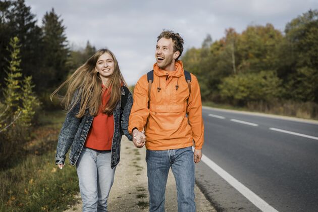 男人一对幸福的夫妇一起在公路旅行的正面视图探险空间户外