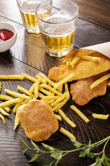 薯条高角度的鱼和薯条在纸锥与啤酒营养番茄酱高角度